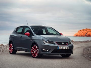 De nieuwe Seat Ibiza, in 2016 gewild onder jongeren, staat geparkeerd aan een weg vlakbij de oceaan.
