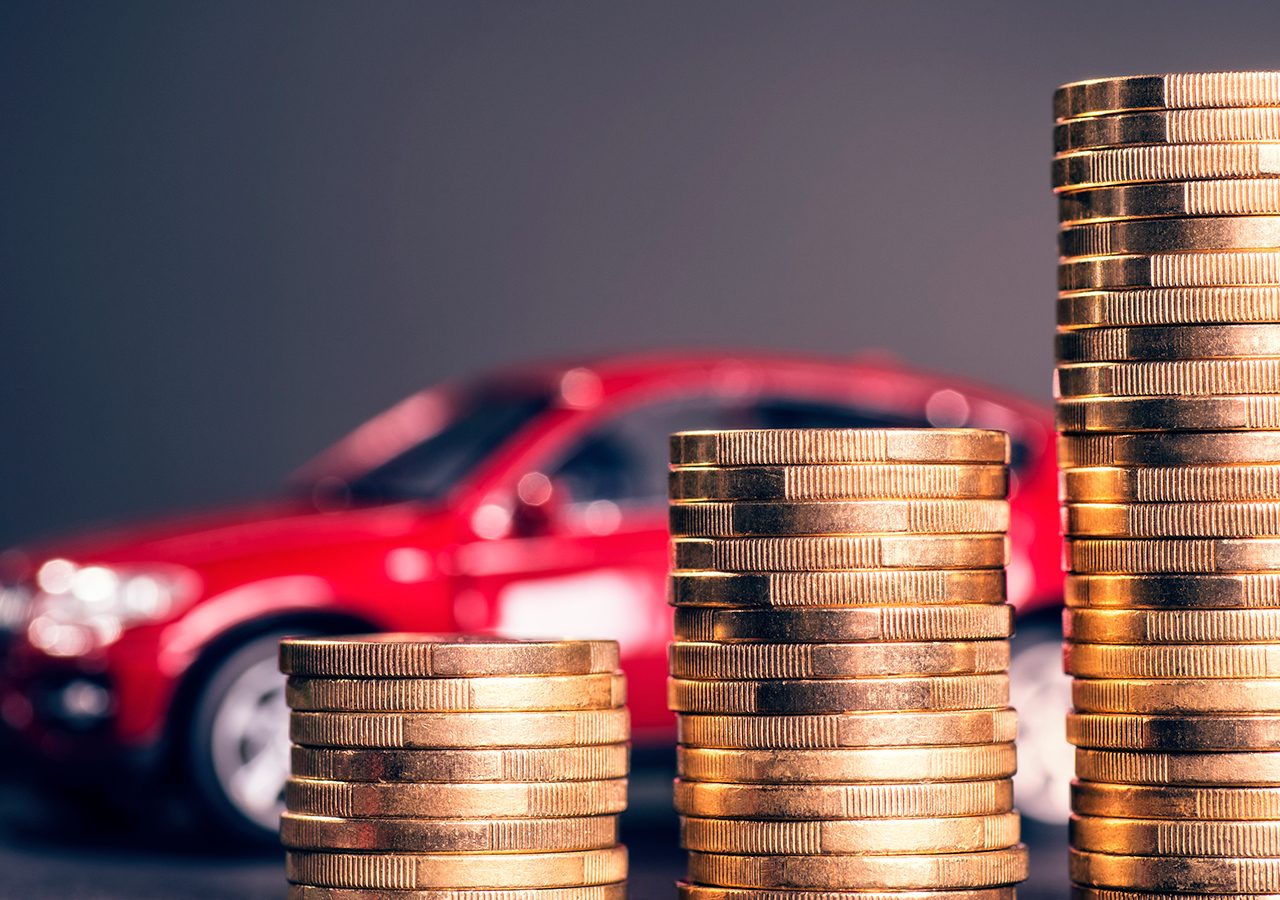 Een stapel munten voor een rode auto, symbool voor de afbouw BPM voor goedkopere auto's.