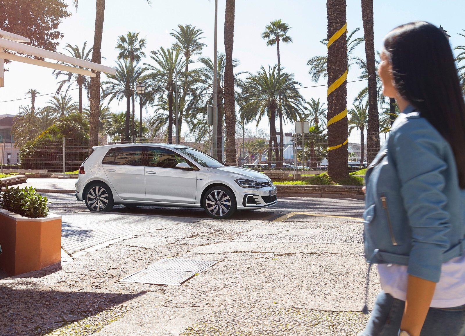 Een vrouw loopt voor een Volkswagen Golf GTI, een van de bestverkochte auto's van 2016.