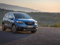 De blauwe Opel Crossland X staat geparkeerd op een heuvel.