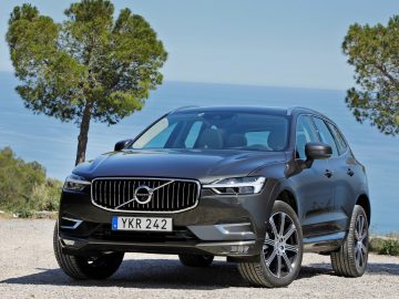 De nieuwe Volvo XC60 staat geparkeerd voor de oceaan.