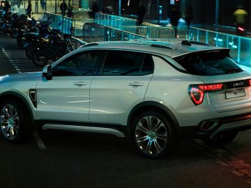 Een witte SUV van Lynk & Co uit 2019 geparkeerd in een straat in de stad Europa.