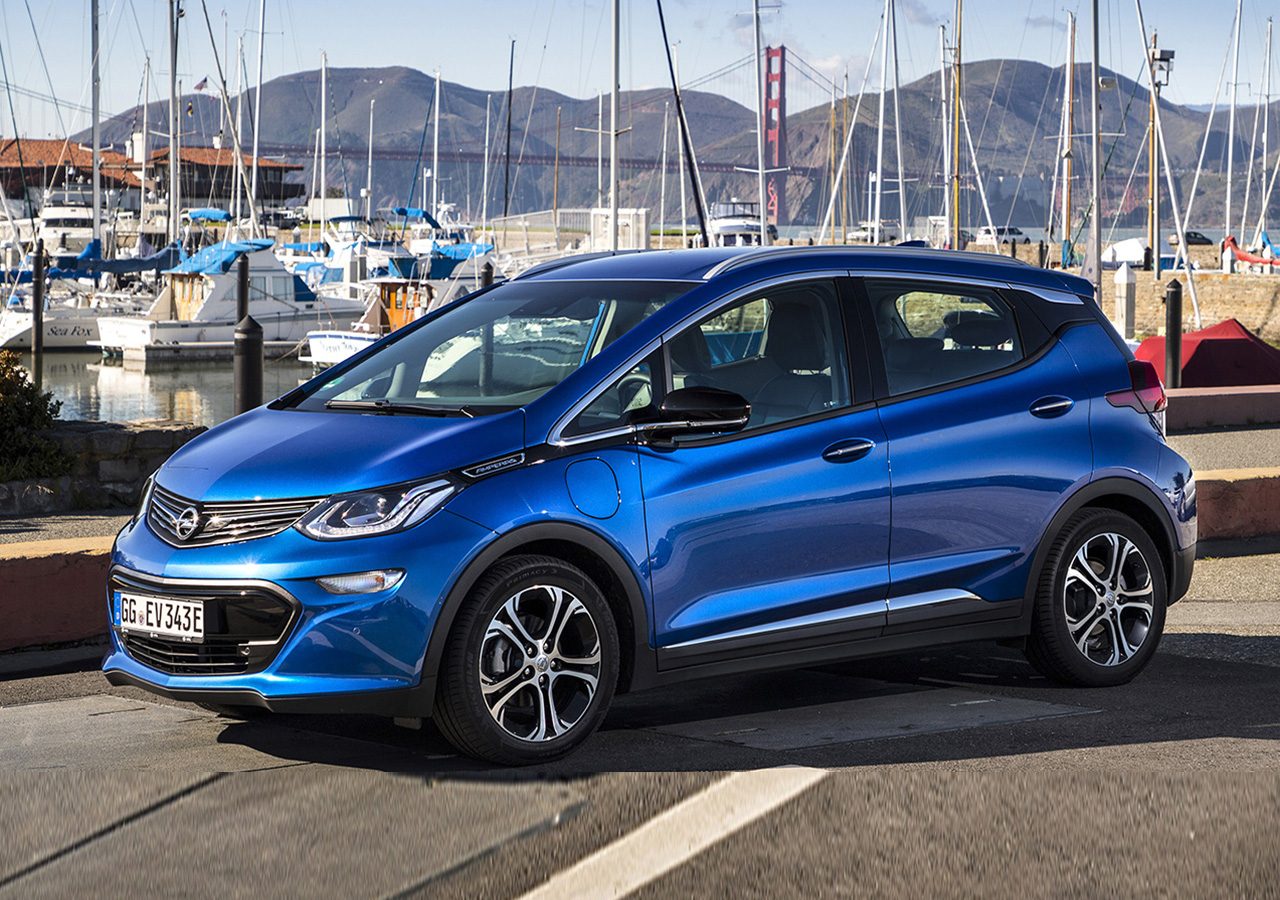 De blauwe Chevrolet Bolt #73 staat geparkeerd voor een jachthaven.