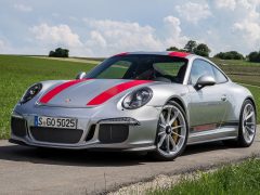 De Porsche 911 GTS rijdt gelukkig over een landweg.