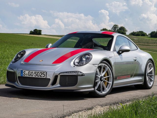 De Porsche 911 GTS rijdt gelukkig over een landweg.