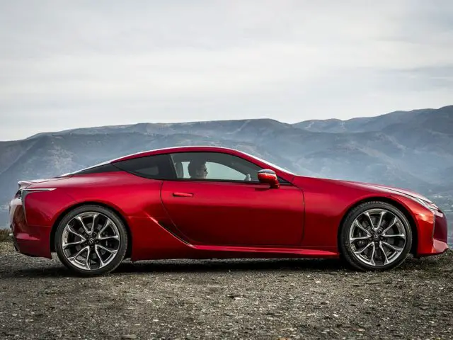 De rode Lexus LC 500h sportwagen staat geparkeerd op een berg.