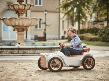 Een kind rijdt op een elektrische loopauto van 3.000 dollar op een binnenplaats.