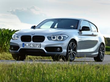 De nieuwe BMW 1-serie hatchback rijdt over een landweggetje.