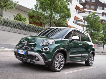 De groene Fiat 500L Cross rijdt door de straat.