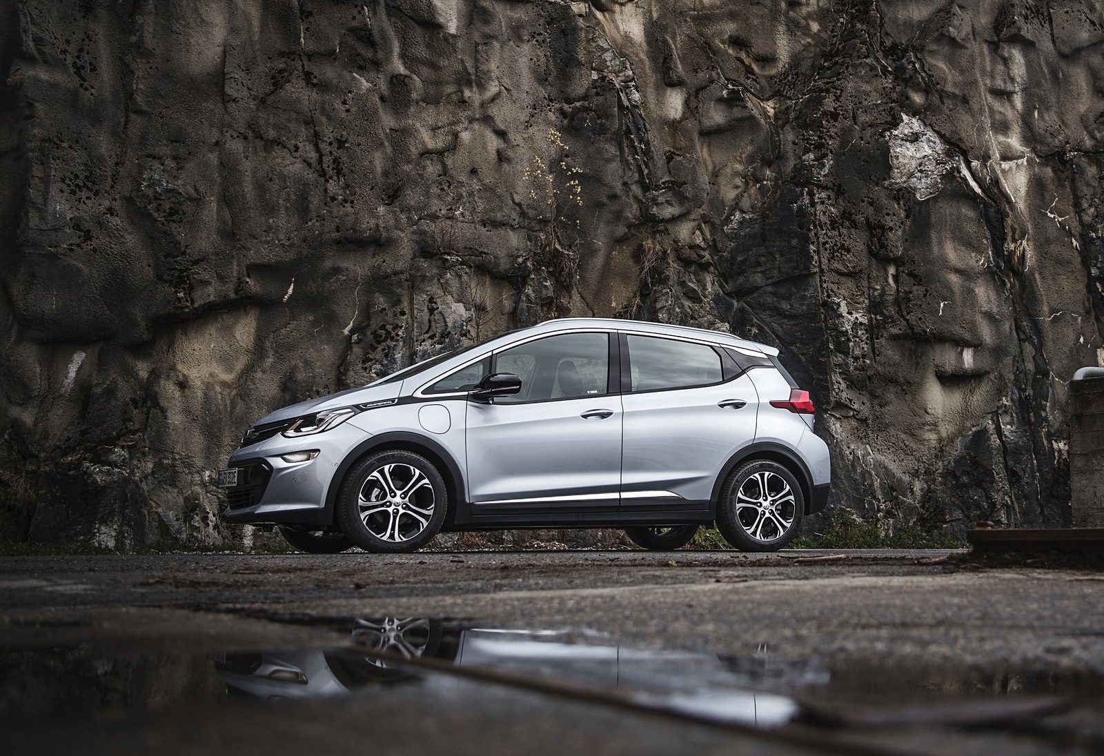 Een zilveren Chevrolet Ampera-e geparkeerd voor een rots.