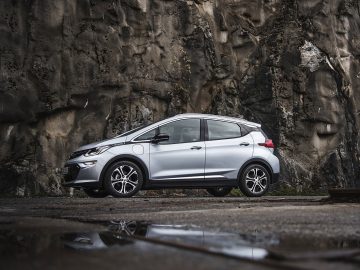 Een zilveren Chevrolet Ampera-e geparkeerd voor een rots.