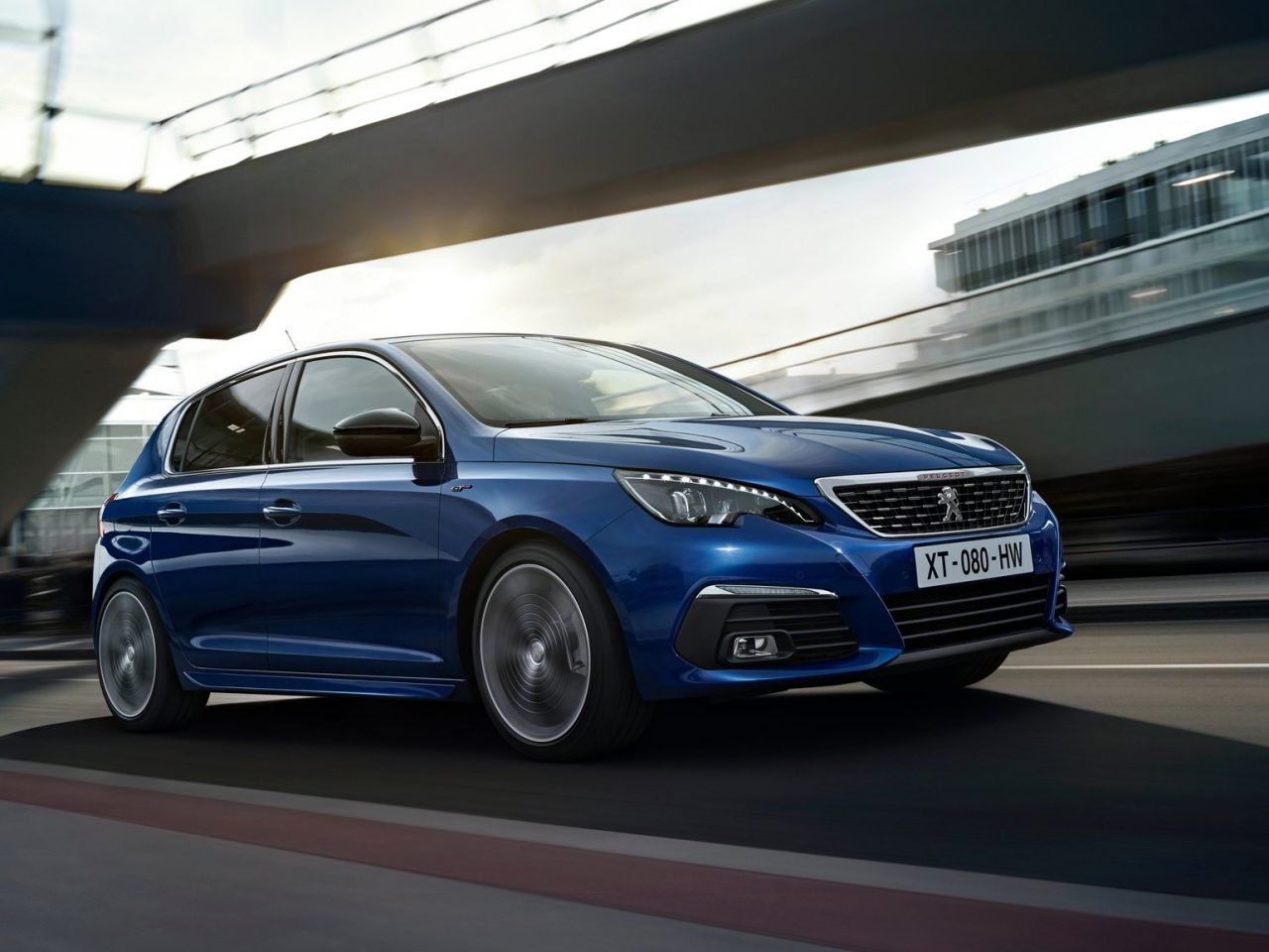 De nieuwe Peugeot 308 rijdt op een brug, te zien in nummer 82 van AutoRAI Daily.