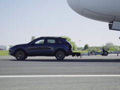 Een Porsche Cayenne S Diesel geparkeerd op het asfalt naast een Airbus A380.