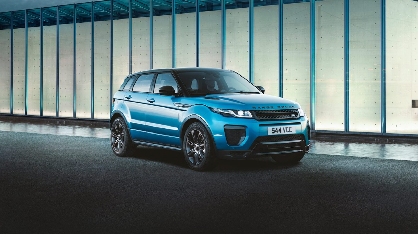 De blauwe Range Rover Evoque staat dagelijks voor een gebouw geparkeerd.