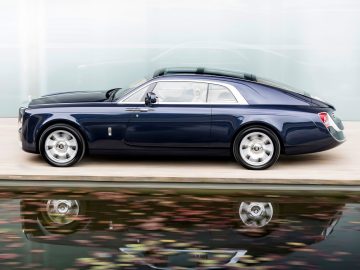 De Rolls Royce Sweptail staat geparkeerd voor een gebouw.