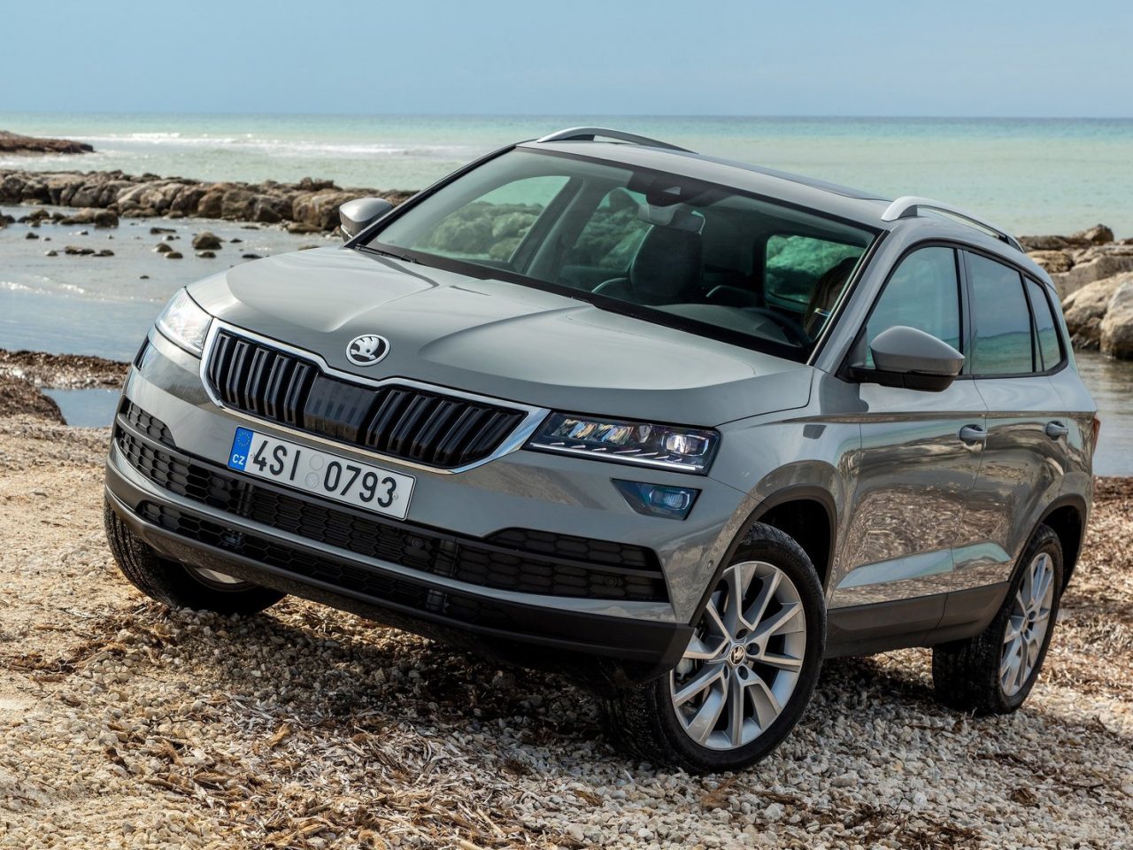 De Skoda Karoq uit 2018 staat geparkeerd op een rotsachtig strand.