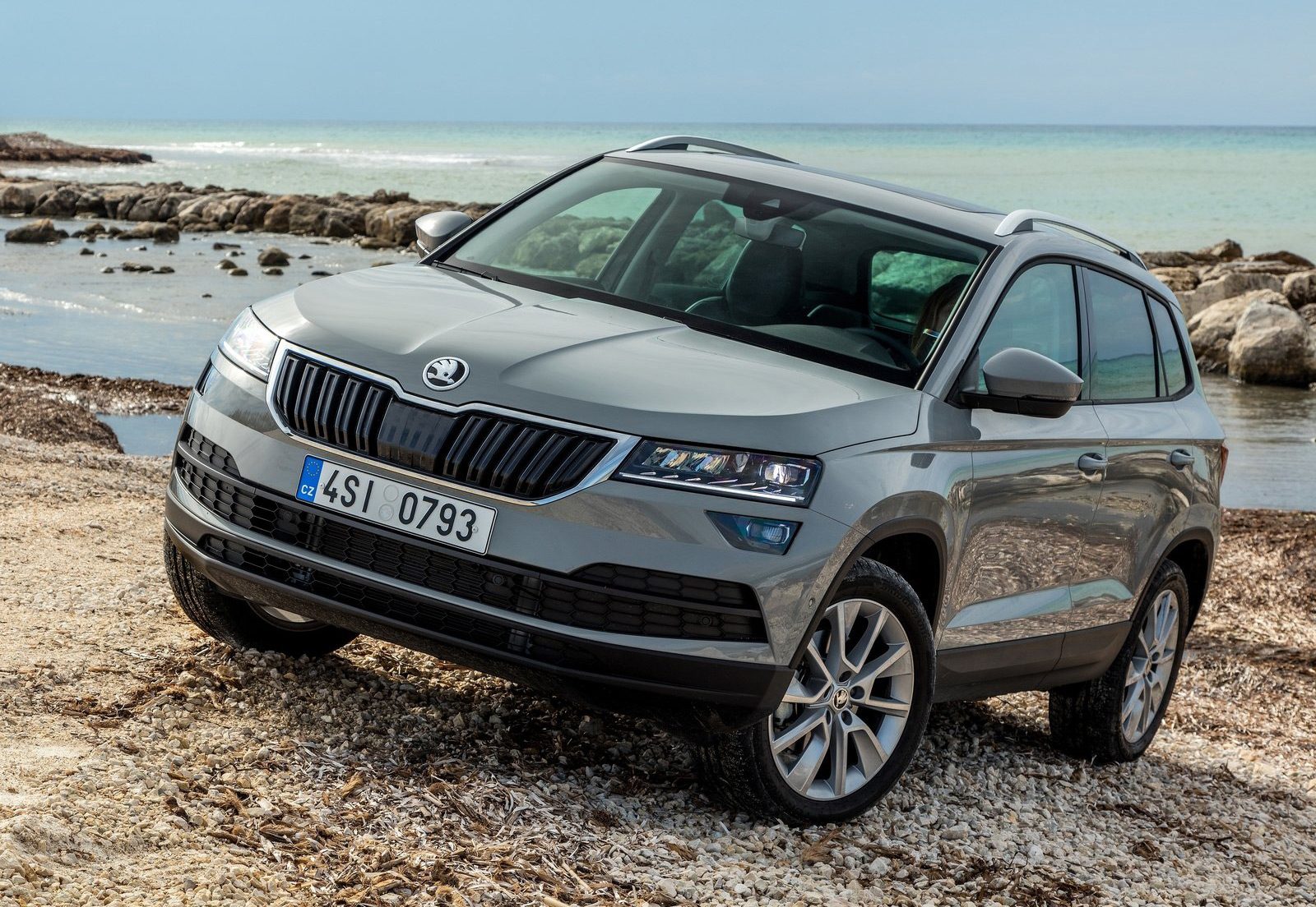 De Skoda Karoq uit 2018 staat geparkeerd op een rotsachtig strand.