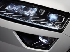 Een close-up van de koplampen van een witte Skoda Karoq.