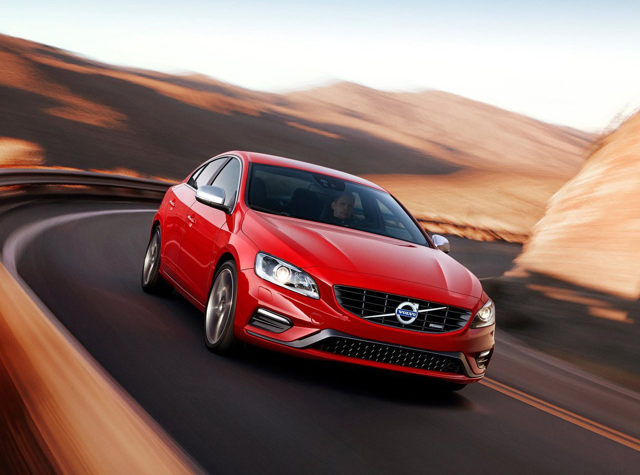 De verzekerde rode Volvo S60 rijdt over een bergweg.