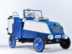 Een kleine blauwe en witte elektrische auto met wielen.