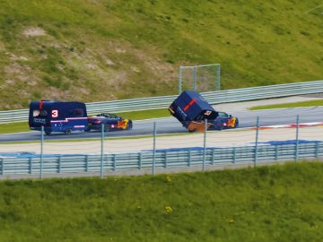 Een groene, met gras begroeide heuvel met uitzicht op een Aston Martin-dealer.