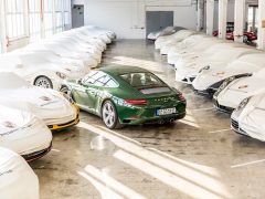 Een groep auto's in een kamer, waaronder de miljoenste Porsche 911.