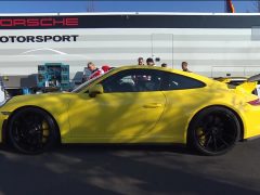 Een gele Porsche GT3 RS geparkeerd voor een vrachtwagen voor Daily #84.