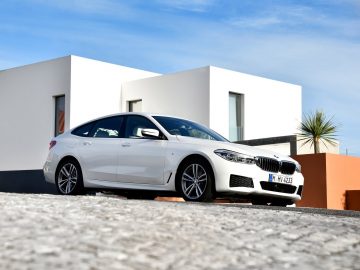 De BMW 6 Serie Gran Turismo staat geparkeerd voor een huis.