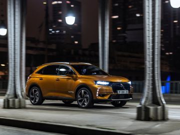 De DS 7 Crossback rijdt 's nachts onder een brug door.