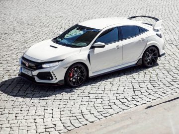 Een witte Honda Civic Type R geparkeerd op een stenen weg.