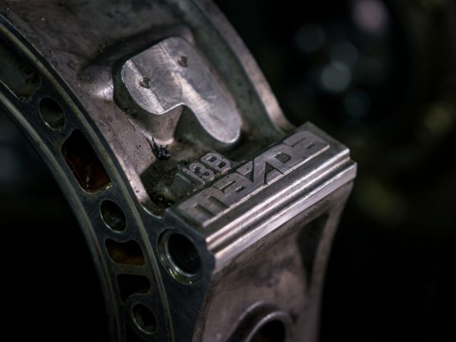 Een close-up van een stuk metaal met een Mazda-logo erop, ter ere van vijftig jaar rotatiemotor.