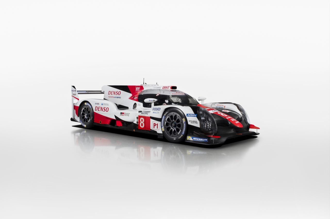 Een rood-witte raceauto met het baanrecord in de hand, op een witte achtergrond.