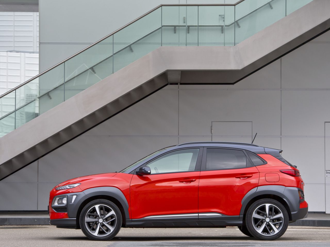 De Hyundai Kona staat voor een gebouw geparkeerd.