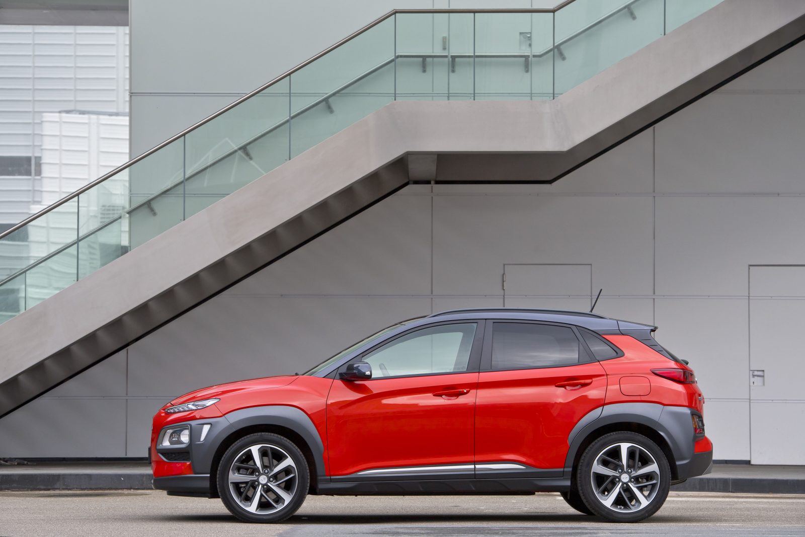 De Hyundai Kona staat voor een gebouw geparkeerd.