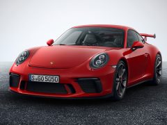 De rode Porsche 911 GTS, afkomstig uit één van de top-10 waardevolste automerken anno 2017, wordt getoond in een studio.