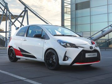 De Toyota Yaris GRMN staat voor een gebouw geparkeerd.