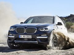 De Nieuwe BMW X3 rijdt door zand.
