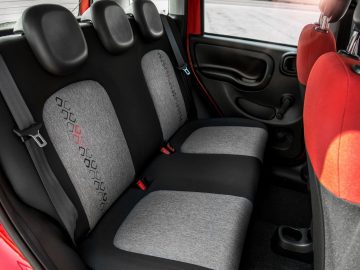 De achterstoelen van een rode en grijze Fiat Panda, waarvan er 1 miljoen zijn geproduceerd.