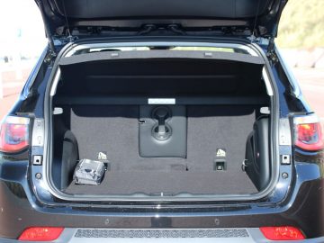 Een zwarte Jeep Compass met open kofferbak.