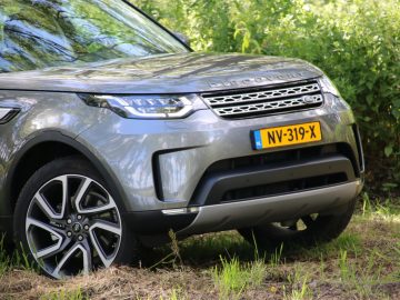 De Land Rover Discovery staat geparkeerd in het gras.