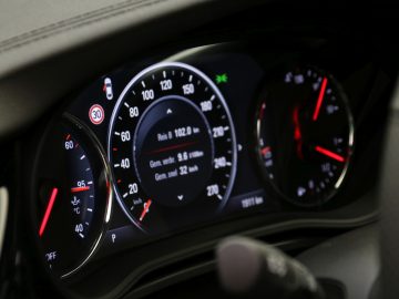 Het dashboard van een Opel Insignia Grand Sport 1.5 Turbo, compleet met snelheidsmeters en meters.