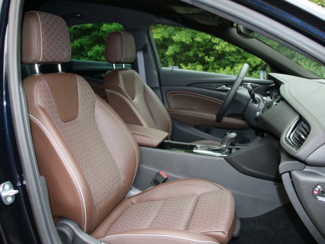 Het interieur van een Opel Insignia Grand Sport 1.5 Turbo met bruin lederen stoelen.