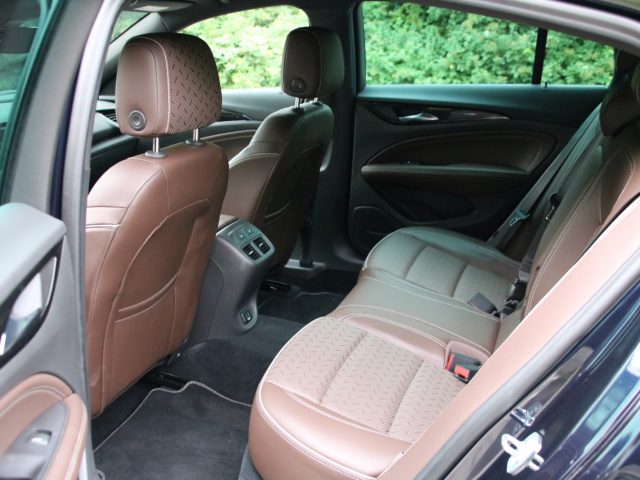 Het interieur van een Opel Insignia Grand Sport 1.5 Turbo met bruin lederen stoelen.