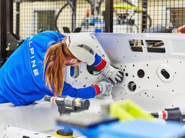 Een vrouw werkt in een fabriek aan een Alpine A110.