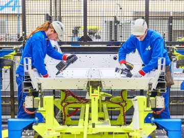 Twee arbeiders maken reportage over de nieuwe A110 Alpine in een fabriek.