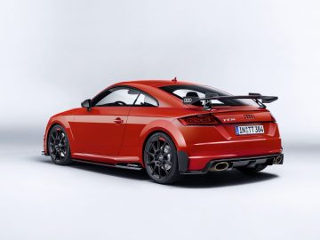 De rode Audi TT RS coupé wordt getoond in een studio.