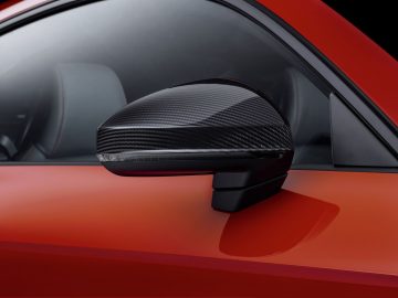 De achteruitkijkspiegel van een rode Audi R8 sportwagen.