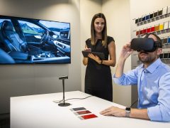 Een man en een vrouw kijken naar een Virtual Reality-headset in een Audi-showroom.