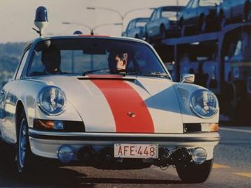Een foto van een politie-Porsche 911-auto die over de weg rijdt.