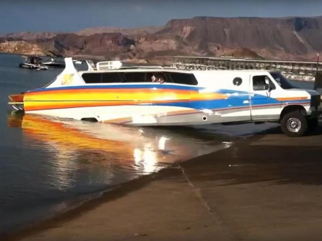 Een boot staat geparkeerd aan de oever van een meer, vlakbij het water.
